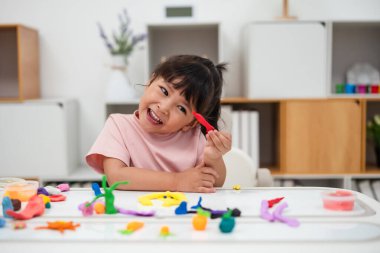 toddler girl with sculpting from plasticine at home
