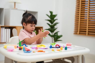 toddler girl with sculpting from plasticine at home