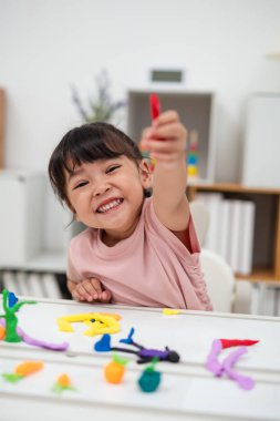 toddler girl with sculpting from plasticine at home