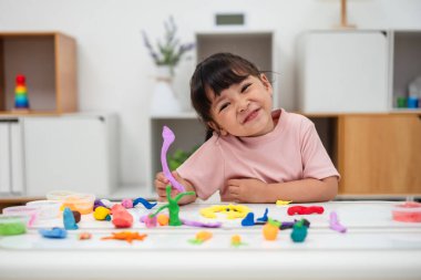 toddler girl with sculpting from plasticine at home