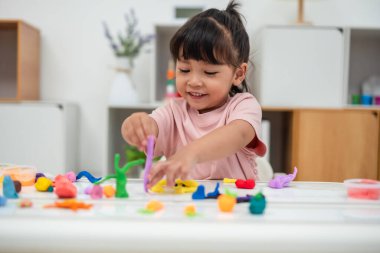 toddler girl with sculpting from plasticine at home