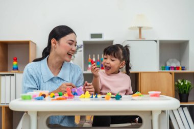 toddler girl with her mother sculpting from plasticine at home