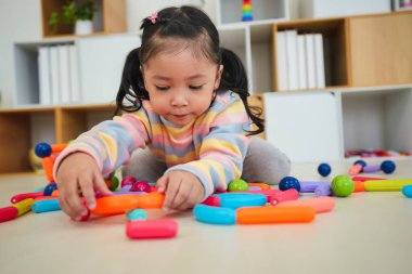Mutlu küçük kız renkli manyetik inşaat oyuncağı oynuyor.