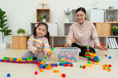 Mutlu küçük kız evde yapı taşı ya da plastik tuğla oyunu oynuyor.