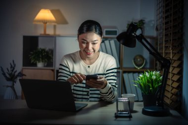 Bir gecede akıllı telefon ve laptopla uyanan bir kadın.