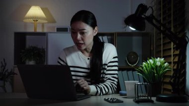 Başarılı kadın bir gecede dizüstü bilgisayarla çalışıyor.