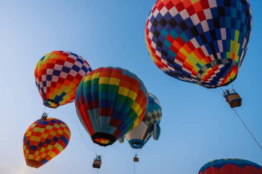 Gökyüzünde parlayan renkli sıcak hava balonları