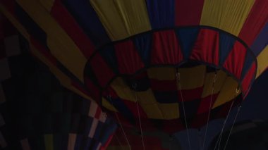Karanlık gece gökyüzünde parlayan renkli sıcak hava balonları