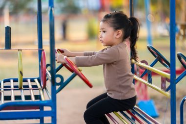 Çocuk kız oyun parkında direksiyon oyuncağıyla oynuyor.