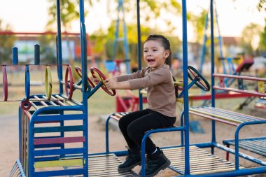 Çocuk kız oyun parkında direksiyon oyuncağıyla oynuyor.
