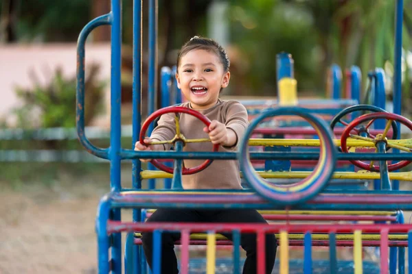 Çocuk kız oyun parkında direksiyon oyuncağıyla oynuyor.