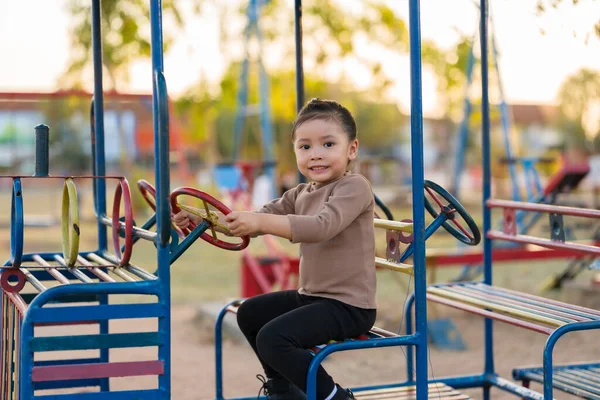 Çocuk kız oyun parkında direksiyon oyuncağıyla oynuyor.
