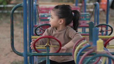 Çocuk kızın çocuk parkında direksiyon oyuncağıyla oynaması.