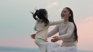 Gün batımında sarılan anne ve çocuğun yürek ısıtan sahnesinin ağır çekimleri.