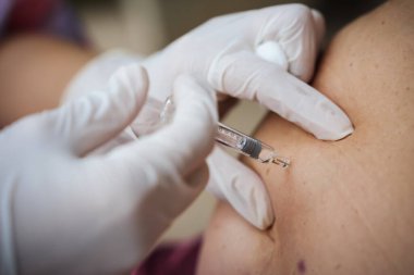 Doktor, karnına enoksiaparin enjeksiyonu yapıyor.