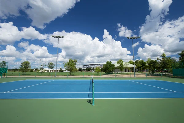 Prázdné venkovní tenisový kurt s modrou oblohou — Stock fotografie