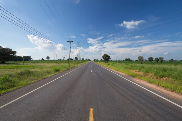 Asphalt road through the green field — Stock Photo, Image