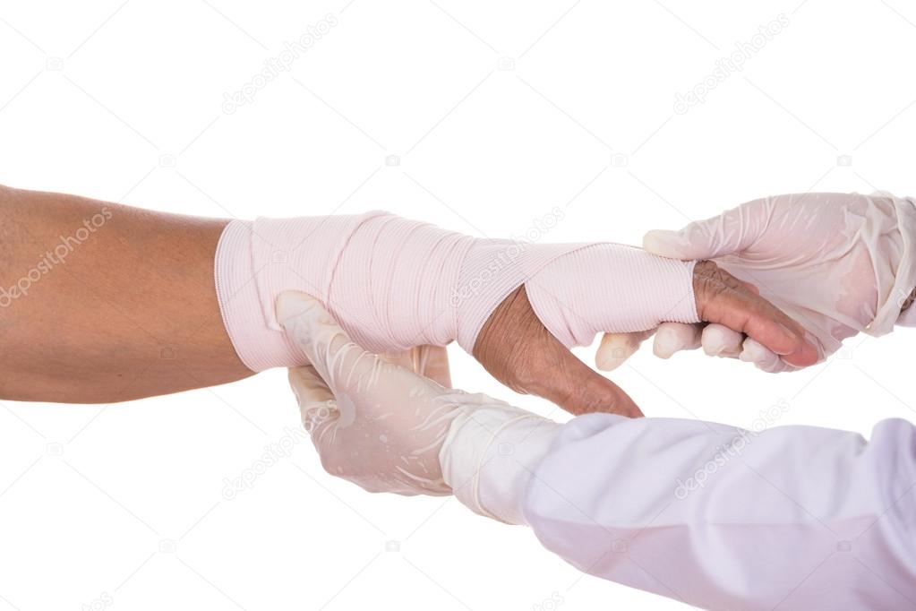 Close-up female doctor is bandaging hand of patient