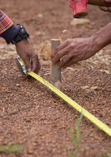 Travailleur travaillant avec ruban à mesurer, marteau et clou — Photo