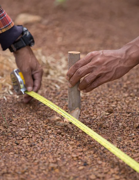 Trabajador que trabaja con cinta métrica, martillo y clavo — Foto de Stock