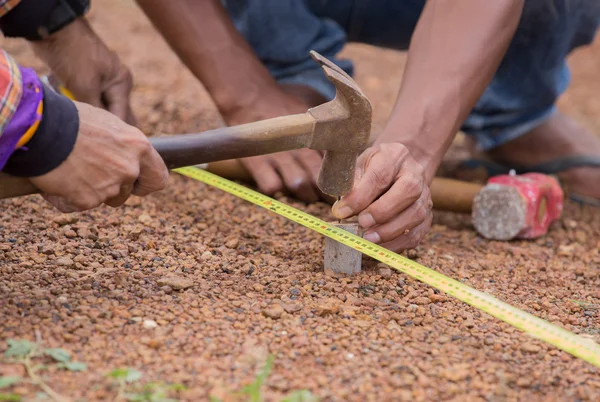 Trabajador que trabaja con cinta métrica, martillo y clavo —  Fotos de Stock