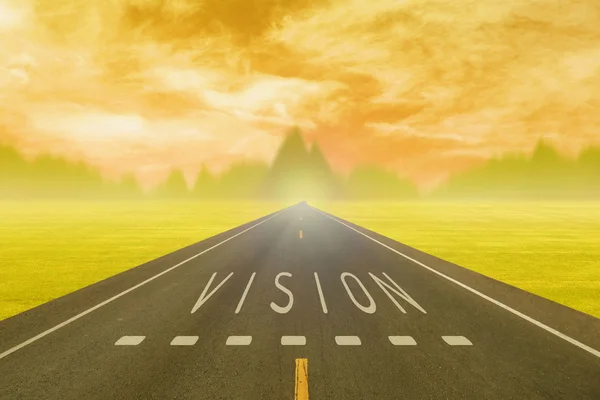 Road through the field with sign vision on asphalt at sunset — Stock Photo, Image