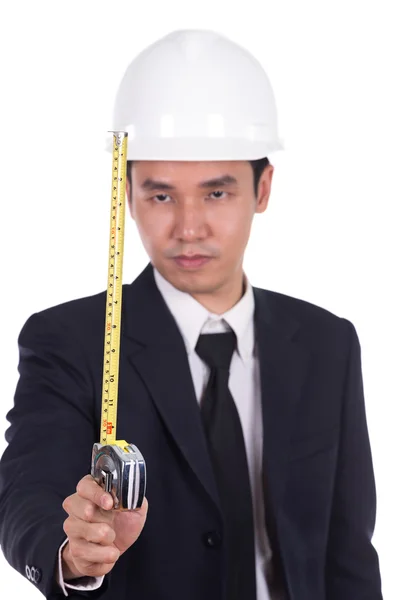Engenheiro em um capacete com uma fita métrica — Fotografia de Stock
