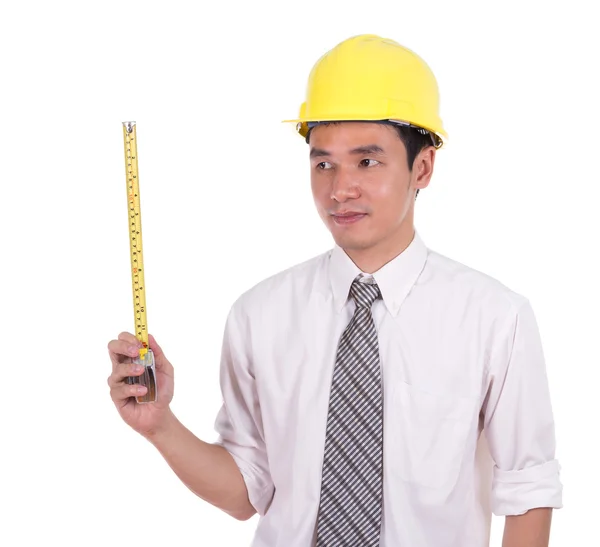 Engenheiro em um capacete com uma fita métrica — Fotografia de Stock