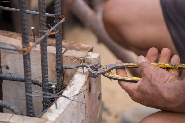 Trabajadores de la construcción manos que trabajan con pinzas en la fijación de acero r — Foto de Stock