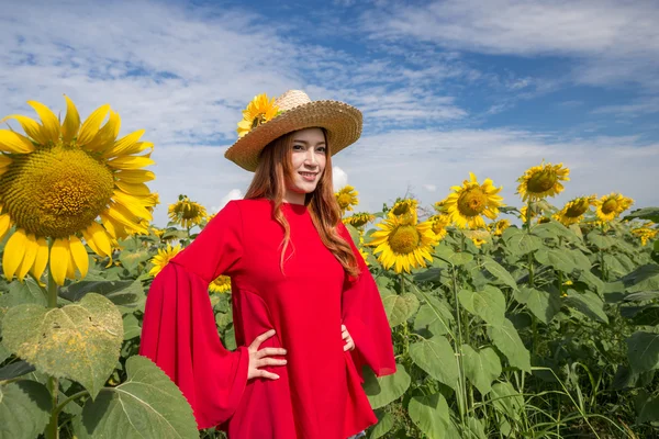 Šťastná žena a ve slunečnicovém poli — Stock fotografie