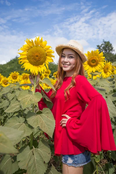 Šťastná žena a ve slunečnicovém poli — Stock fotografie