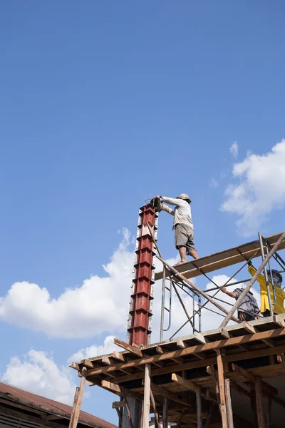 Arbeiter gießt Zement in Betonpfeilerform für Hausbau — Stockfoto