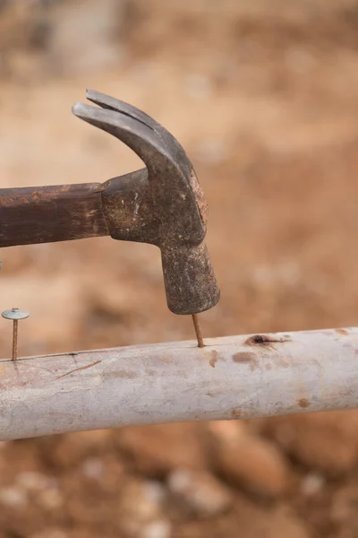 Worker hammering nail into wood — Stock Photo, Image