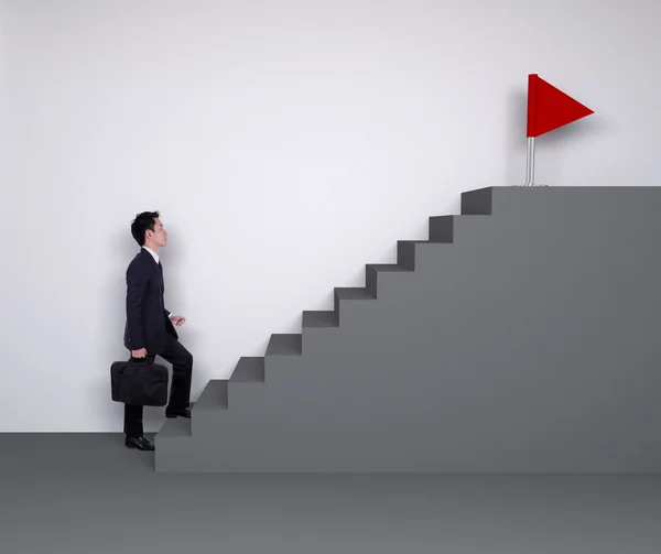 Business man stepping up on stairs to red flag (business success — 스톡 사진