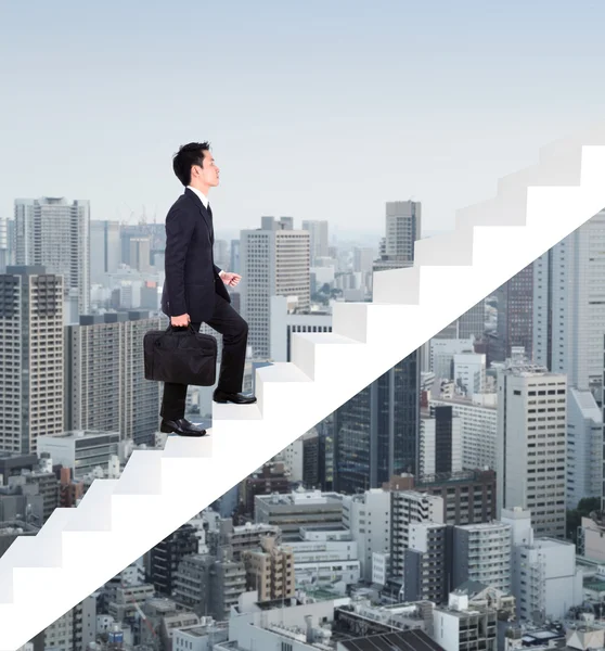 Hombre de negocios subiendo escaleras con el fondo de la ciudad — Foto de Stock