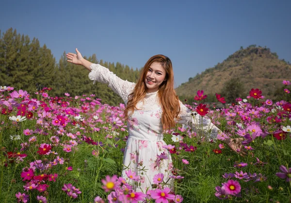 Mujer con campo de flores cosmos — Foto de Stock