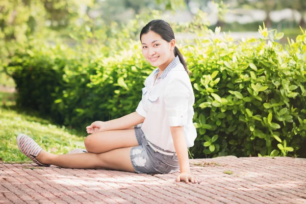 Jonge Aziatische vrouw ontspannen buitenshuis op zoek gelukkig en lachende — Stockfoto