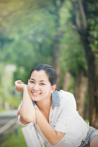 Açık havada mutlu ve gülümseyerek seyir rahatlatıcı genç Asyalı kadın — Stok fotoğraf