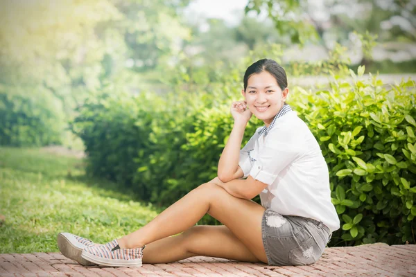 Joven asiático mujer relajante al aire libre buscando feliz y sonriente — Foto de Stock