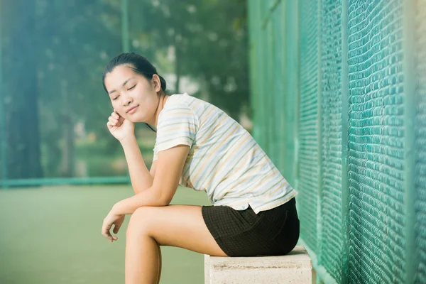 Asiático feminino relaxar e sorrir de pé no campo de ténis — Fotografia de Stock