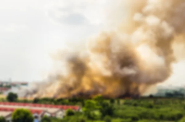 Blur effect of Forest fires in the city, causing a large flame and smoke in the air is very hot days. Firemen rush to help prevent the spread of fire to the village — Stock Photo, Image
