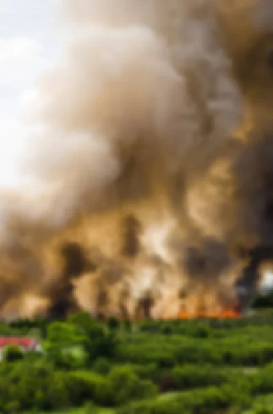 Verwischungseffekt von Waldbränden in der Stadt, wodurch eine große Flamme und Rauch in der Luft ist sehr heiß Tage. Feuerwehrleute eilen herbei, um ein Übergreifen des Feuers auf das Dorf zu verhindern — Stockfoto