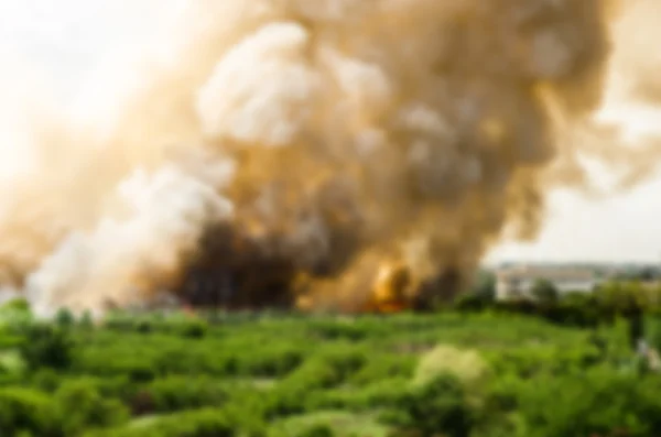 Verwischungseffekt von Waldbränden in der Stadt, wodurch eine große Flamme und Rauch in der Luft ist sehr heiß Tage. Feuerwehrleute eilen herbei, um ein Übergreifen des Feuers auf das Dorf zu verhindern — Stockfoto