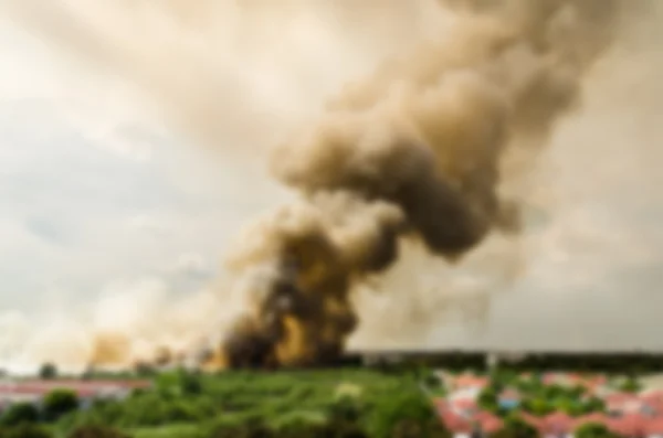 Blur hatása erdőtüzek a városban, ami egy nagy láng és füst a levegőben nagyon forró nap. Tűzoltók rohanás segít megelőzni a tűz terjedését a falu — Stock Fotó