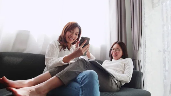 Adorável Casal Asiático Deitado Sofá Jogar Smartphone Com Amigo Sentado — Fotografia de Stock