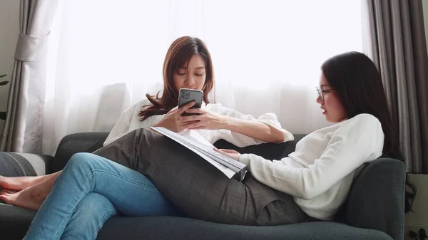 Mooi Aziatisch Paar Liggend Bank Spelen Smartphone Met Een Vriend — Stockfoto