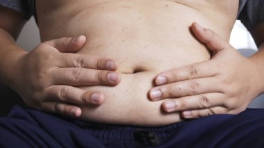 Adam sürekli karın ağrısı yüzünden elini karnına bastırıyor.