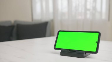 Çalışma alanı üzerinde yeşil ekran ile tablo üzerinde akıllı telefon dikey ekran.