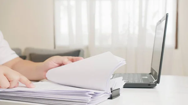 Ben evde çalışıyorum. Uzak çalışma sırasında belgeleri ve verileri inceleyen genç yetişkin.