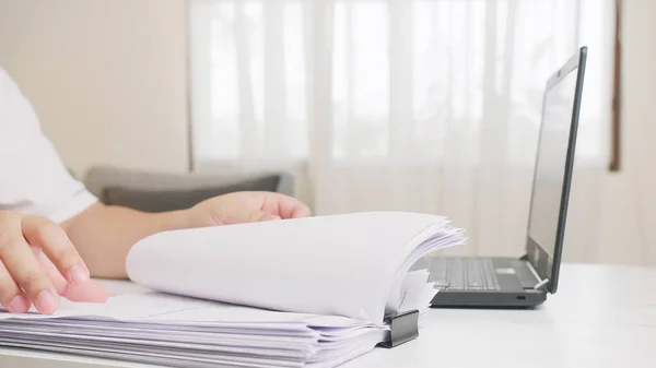 Ben evde çalışıyorum. Uzak çalışma sırasında belgeleri ve verileri inceleyen genç yetişkin.